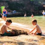 Dwóch chłopców bawi się piaskiem na plaży