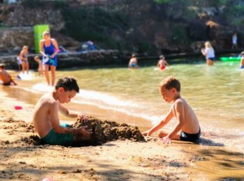Dwóch chłopców bawi się piaskiem na plaży